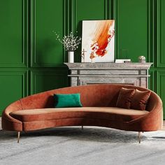 a living room with green walls and a curved couch in front of a fire place