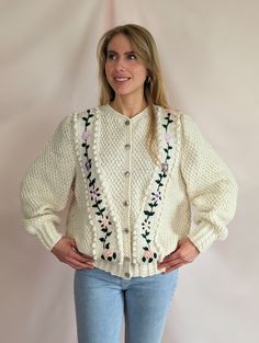 "True vintage 1980s hand knitted Austrian folk wool cardigan. Adorable piece of handwork. Chunky, bouncy, warm wool, solid blend, not itchy, it doesn't bobble. Puffy sleeve, typical for Victorian inspired 80s trends. Beautiful floral embroidery, clear glass and silver tone metal buttons of great quality, all intact. Cardigan is clean and in flawless condition, barely any signs of wear/age. Suitable for all seasons. Truly lovely quality.  Model is size UK 8/ EU 36/ S and 5'7. Best fit M/L  pit to Vintage Handmade Cardigan For Spring, Handmade Vintage Cardigan For Spring, Vintage Cream Sweater With Floral Embroidery, Hand Knitted Cream Cardigan For Spring, Vintage Knitted Spring Cardigan, Spring Cream Knitted Cardigan, Vintage Knitted Sweater For Spring, 80s Trends, Cream Cardigan