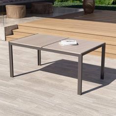 a coffee table sitting on top of a hard wood floor next to a planter