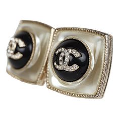 These Chanel Pearl stud earrings in light gold tone hardware, features a square shaped earring with a round black enamel button with the signature CC logo in faux crystals in the center. They also have post back closure.Origin: FranceCondition: Never wornAccompanied by: Chanel boxMeasurements: .75" x .75" Luxury Metal Clip-on Earrings For Evening, Luxury Silver Enamel Earrings, Luxury Metal Clip-on Earrings For Formal Occasions, Designer Metal Clip-on Earrings For Formal Occasions, Luxury Metal Clip-on Earrings, Chanel Pearl, Chanel Pearls, Cc Logo, Pearl Stud Earrings