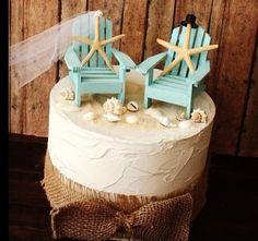 two chairs with starfish on them are sitting on top of a white frosted cake