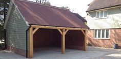 a garage with a brown roof and two cars parked in the driveway next to it