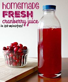 a bottle of cranberry juice next to a bowl of cherries