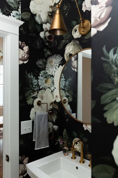 a white sink sitting under a bathroom mirror next to a wall mounted faucet