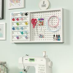 a sewing machine sitting on top of a table next to a wall mounted pegboard