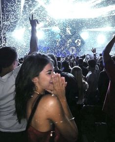 a woman standing in front of a crowd at a concert