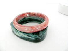 Nice set of 2 bangle bracelets from the 1980's.  Bracelets are plastic and one is round with pink and white swirls, and the other is triangular with green and white swirls (cool marbleized effect).   Bracelets measure approximately 7-3/4" in diameter (interior diameter).  Good vintage condition! For more fabulous bracelets, check out the Vintage Bracelets/Earrings section of my shop: https://www.etsy.com/shop/ThirstyOwlVintage?section_id=18745312Or to see all my vintage treasures, check out the Pink Plastic Bangle Bracelet, Pink Plastic Bangle Jewelry, Pink Bangles, Bracelets Green, Vintage Bangle Bracelets, Vintage Bangles, Bracelets Set, Stackable Bracelets, Vintage Bracelets