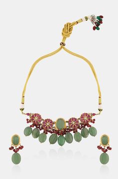 Elevate your outfit with our elegant necklace set, featuring a stunning centerpiece adorned with a beautiful green jade stone. Surrounding the centerpiece is a floral pattern embellished with red garnet stones, accented with red onyx and green jade stones, adding a touch of elegance and sophistication. Complete your look with the matching earrings for a coordinated and stylish ensemble. Finish: 22KT Gold Plating Material: Silver, Copper Alloy, Semi Precious Stones Color: Green Size: Free Size, A Festive Green Gemstone Jewelry Sets, Green Emerald Jewelry For Gift, Green Gemstone Temple Jewelry Sets, Festive Green Emerald Gemstone Necklace, Festive Green Jewelry Sets With Stones, Festive Green Stone Jewelry Sets, Traditional Green Gemstone Jewelry Sets, Festive Green Stone Necklaces, Festive Green Necklace With Stones