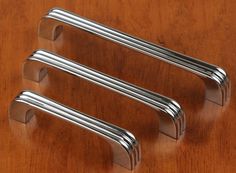 two stainless steel handles on a wooden table