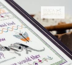 a cross stitch sample with the words and pictures on it, in front of some other items