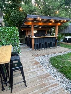 an outdoor bar is set up in the middle of a backyard with lots of greenery