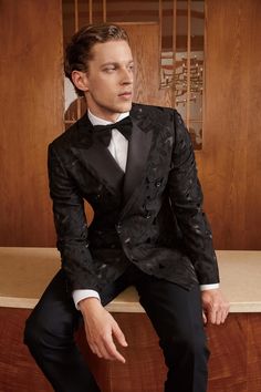 Embroidered Black Custom Wedding Tuxedo This black embroidered wedding tuxedo is the perfect way to make a statement on your big day. The luxurious black wool fabric is beautifully complemented by the intricate embroidery, which features a delicate floral pattern. The jacket has a classic double-breasted design with peak lapels and silk facing. The trousers have a slim fit and a satin side stripe. This tuxedo is sure to turn heads and make you look stunning at your wedding. Features: Black wool fabric Intricate floral embroidery Double-breasted jacket with peak lapels Silk embroidery Customize it: All of our clothing is handcrafted at the time of order. This provides you the opportunity to customize the clothing however you like. Free monogramming included! Inside the left jacket will say Mexican Tuxedo Grooms, Embroidered Tuxedo, Embroidered Suits, Unique Tuxedos, Vintage Glamour Wedding, Tuxedo Wedding Suit, Custom Tuxedo, Wedding Tux, Black Tux