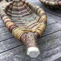 a close up of a basket on a wooden table with wood planks and paint