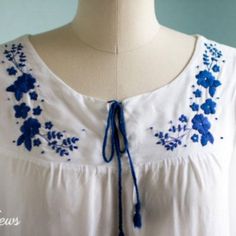 a white dress with blue flowers on it