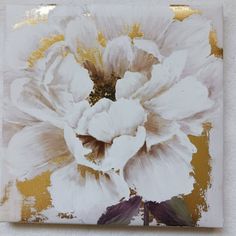 a white flower on a gold and white background