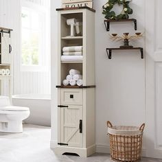 a bathroom with a white toilet and wooden cabinet