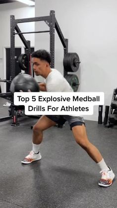 a man squatting in the middle of a gym with an exercise ball behind him