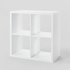 a white cube shelf with four sections on each side and one section missing from the top