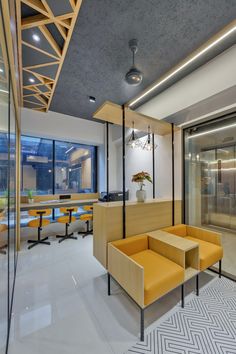 an office lobby with yellow chairs and tables