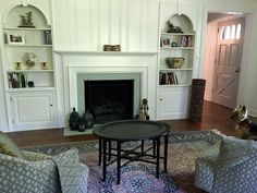 a living room filled with furniture and a fire place in the middle of a room