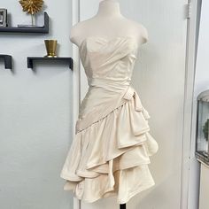 a mannequin wearing a white dress in front of a door