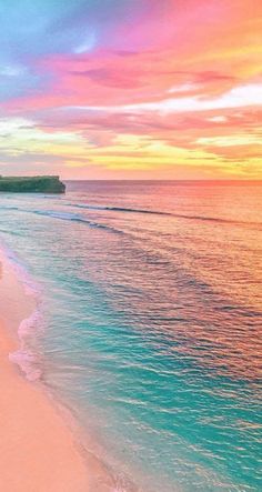 the beach is empty and there are people walking on the sand near the water's edge