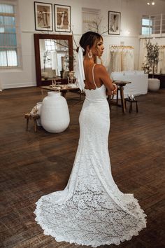 a woman in a wedding dress is standing on the floor with her back to the camera