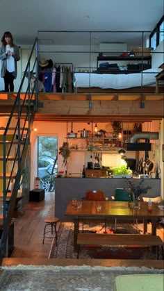 a living room filled with furniture next to a staircase leading up to a loft bed