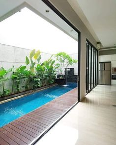 an indoor swimming pool in the middle of a room with sliding glass doors leading outside