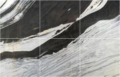 black and white marble tiles are arranged in an abstract pattern with gold accents on the edges