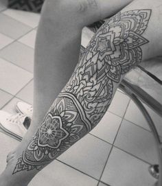 a woman's leg with an intricate tattoo design on her left arm and foot