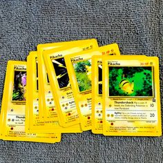 five pokemon trading cards sitting on top of a gray blanket next to eachother