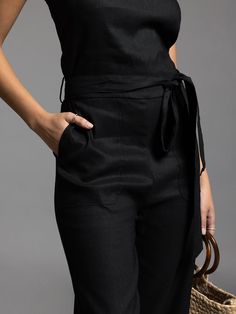 Style Description: Jumpsuit Crew neckline Tie waist detail Measurements for a size small: Chest: 17" Rise: 11" Inseam: 24.5" Fabric Content/Care: 52% Linen 46% Rayon 2% Spandex Machine Wash ColdImport Black Jumpsuits And Rompers With Side Pockets For Summer, Chic Workwear Jumpsuits And Rompers With Side Pockets, Black Pantsuit With Pockets For Work, Black Workwear Pantsuit With Pockets, Chic Overalls With Pockets, Black Summer Overalls For Workwear, Black Jumpsuits And Rompers With Side Pockets For Spring, Black Summer Workwear Overalls, Fitted Overalls For Workwear