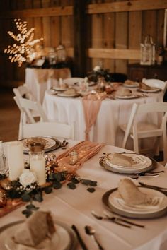 the table is set with white linens and place settings for dinner guests to eat