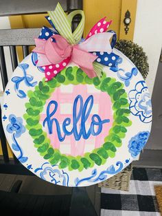 a hand painted door hanger with the word hello written in blue, pink and green