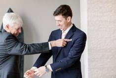 two men in suits and ties are touching each other's hands with their fingers