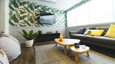 a living room filled with furniture and a flat screen tv mounted on the wall above it