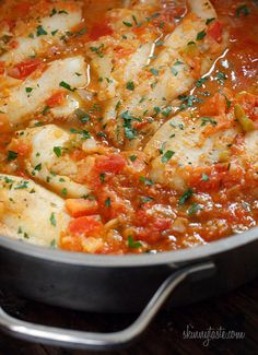 a pan filled with fish covered in tomato sauce