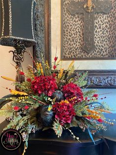 a vase filled with lots of flowers on top of a table next to a mirror