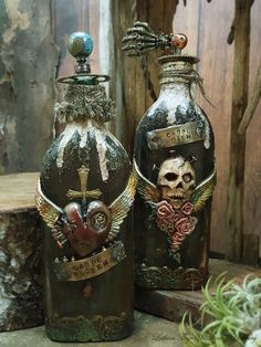 two vases are decorated with skulls and wings