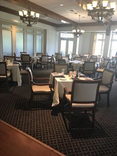 a dining room with tables and chairs set up for an event or function in front of large windows