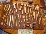 many different types of tools on a table next to a one dollar bill and some rocks