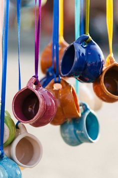 colorful cups hanging from hooks on the wall