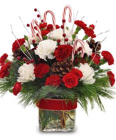 a christmas arrangement with candy canes, carnations and pine cones