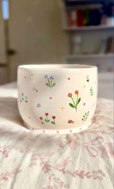 a white bowl sitting on top of a bed