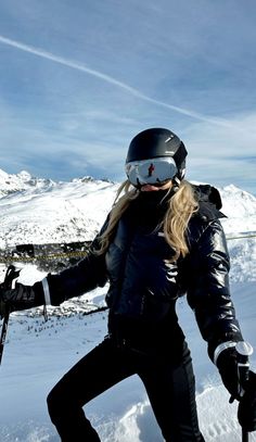 a woman on skis in the snow with her arms out and one hand behind her back