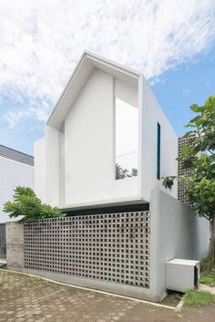 a white house with an interesting design on the front and side walls that are made out of cement blocks