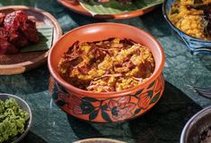 an assortment of food is displayed in bowls on a table with other plates and utensils