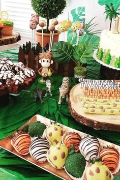 an assortment of desserts on display at a jungle birthday party