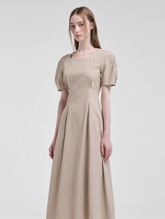 This product showcases a seamless blend of classic design with modern elements, featuring a square neckline paired with delicate pintuck details for a structured yet soft appearance. The design gracefully accentuates the waist before flaring into a flowing skirt, offering both style and movement. With its short puff sleeves, the dress captures a romantic essence, perfect for various occasions. - The square neckline provides a timeless elegance to the dress, while pintuck detailing adds a touch of sophistication.- Puff sleeves lend a feminine charm and gentle volume, complementing the fitted waist.- The dress flows into a full skirt, designed to move beautifully and give a flattering silhouette.- A handmade Cali medal decoration has been attached to the lower right side of the front pa Classic Solid Midi Dress With Pleated Waist, Midi Dress With Pleated Bodice, Classic Beige Dresses With Pleated Waist, Classic Beige Dress With Pleated Waist, Square Neck Midi Dress With Pleated Sleeves, Feminine Pleated Square Neck Dress, Classic Fitted Midi Dress With Pleated Back, Pleated Square Neck Dress In Solid Color, Classic Pleated Beige Midi Dress